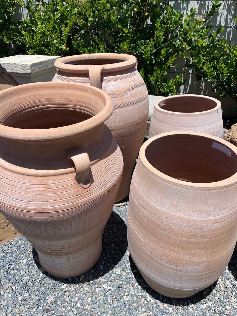 A grouping of handled terra cotta pots and planters